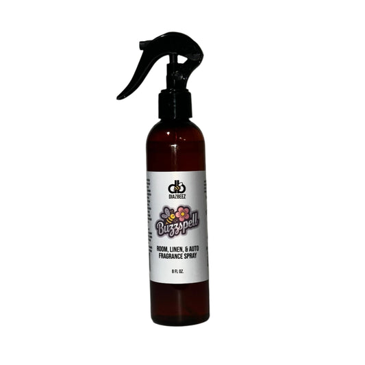 A dark amber spray bottle featuring a black trigger nozzle, labeled "Buzzspell Room, Linen, & Auto Fragrance Spray" from Diaz Beez, makes an ideal unisex fragrance. The vibrant graphics and text on the 8-fluid-ounce bottle beautifully capture the essence of Buzzspell’s enchanting aroma.