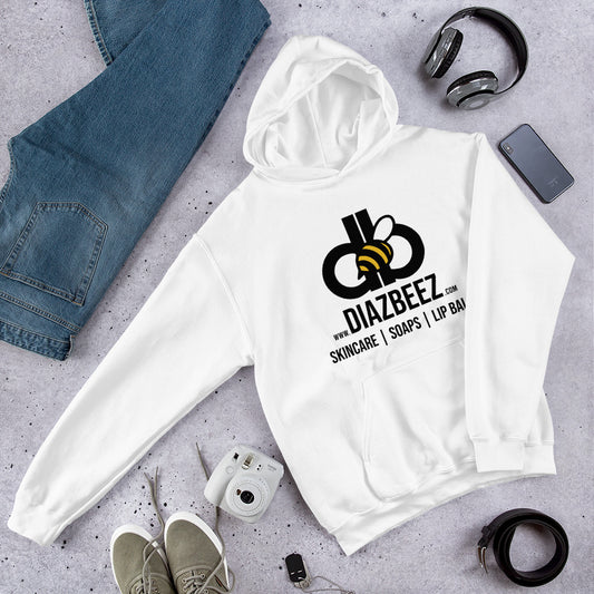 A cozy and stylish Unisex Hoodie from Diaz Beez, featuring a beehive-inspired bee logo and the text "Skincare | Soaps | Lip Balm" in white. It's surrounded by jeans, sneakers, headphones, a camera, watch, and a plant on a textured surface.